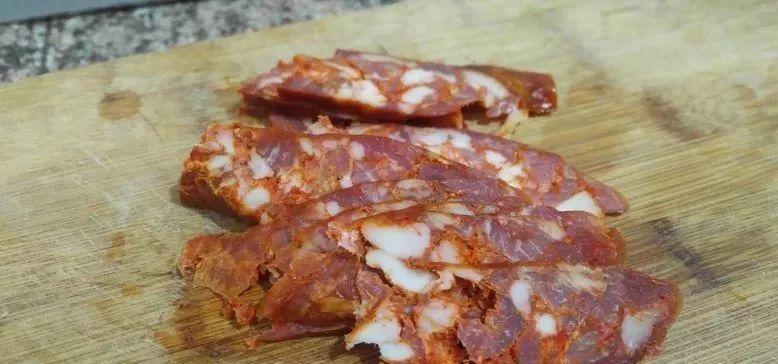 一片土豆压一片腊肠, 蒸一蒸, 撒上料汁, 入口即化