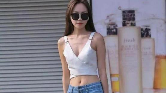 街拍：白色露脐深V背心配修身蓝色牛仔裤，超显腿长