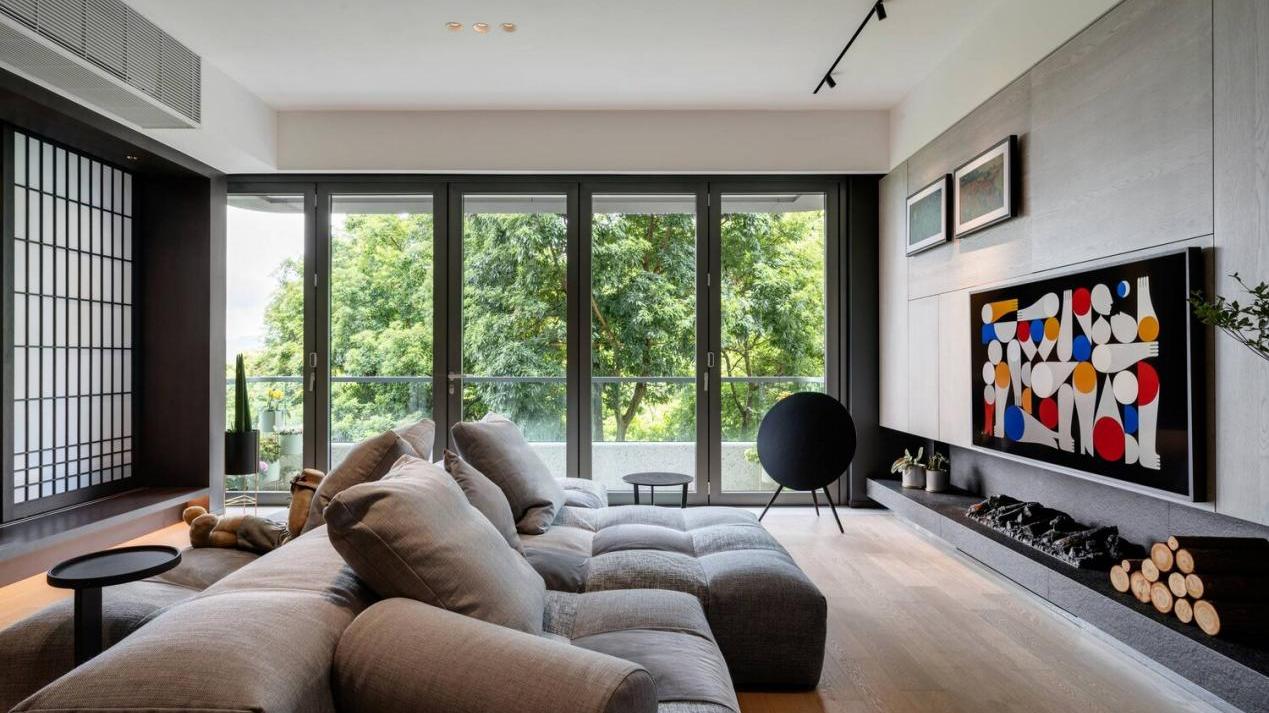 150㎡深色质感家，客厅带有大面积落地窗，欣赏到郁郁葱葱的景观
