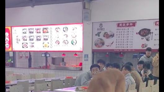 狗狗在学校食堂餐桌上舔食物，学生们抱着碗躲避，据说是主任的？