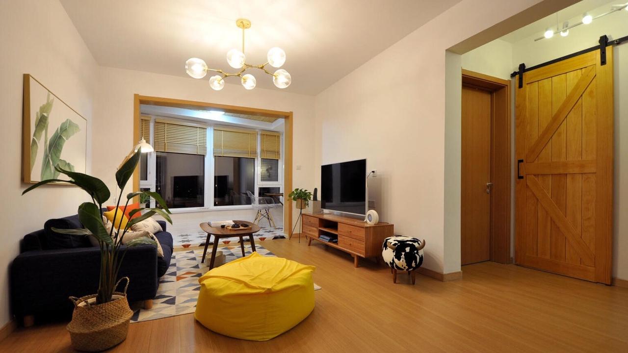 121平日剧三居室，黄色的懒人沙发与绿植给客厅增添了抹亮色