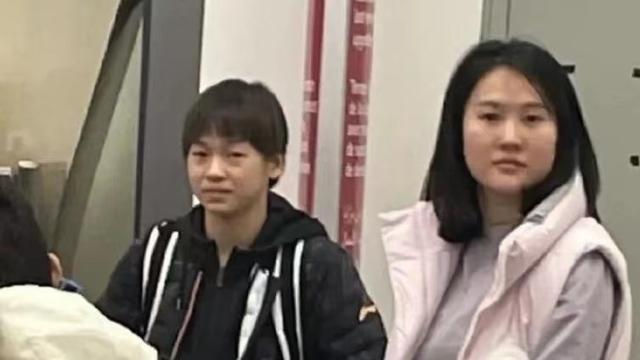 全红婵戴2金载誉回国！穿羽绒服+脚蹬拖鞋+拖2个行李箱，太可爱了