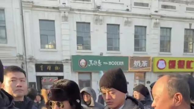 马英九到哈尔滨逛街，戴着棉帽和手套，两个安保人员紧贴左右