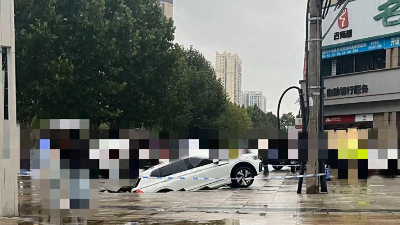 阆中市华胥路工行附近, 一辆白色车子居然"掉进"了路面之中