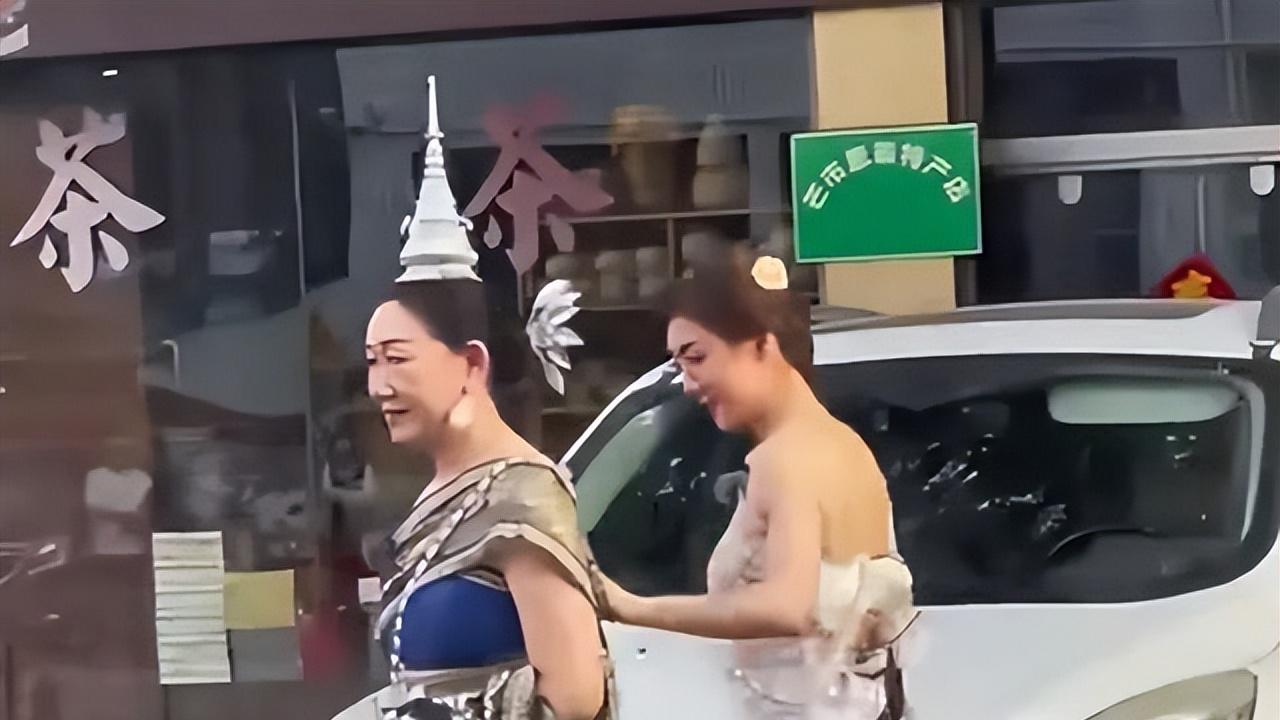 陈梦半露香肩和美背 身穿傣族服饰 帮妈妈整理衣服 母女长相一模一样