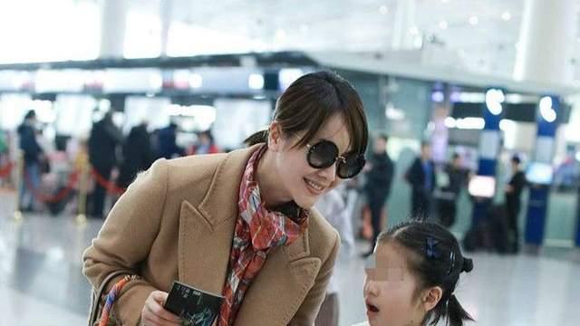 左小青带女儿现身机场，驼色大衣配彩色围巾时尚高级，差点认不出