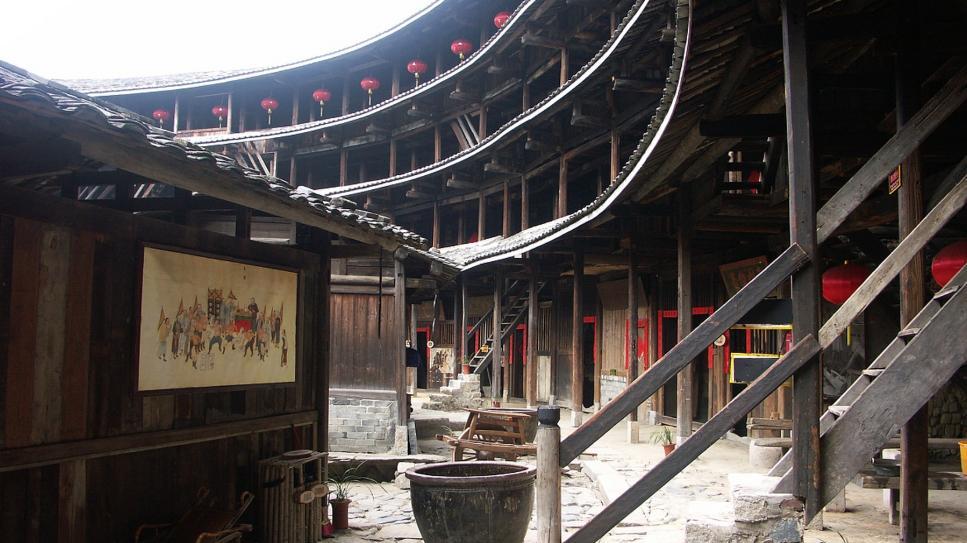 福建有一片土楼群，100元可以体验土楼民宿，站在天井可聚财纳福