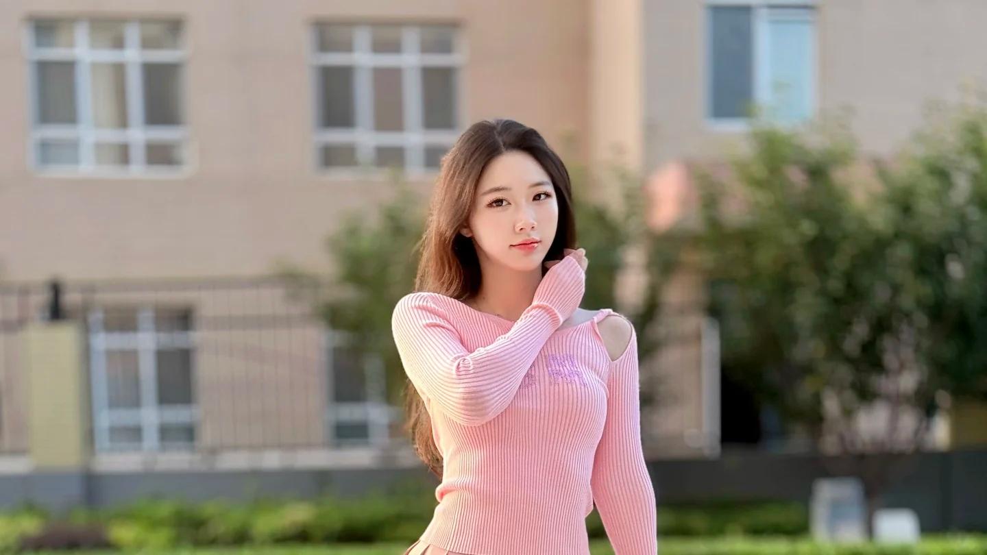 露肩粉针织搭百褶裙：同色高跟鞋踏过，户外场景里藏着甜