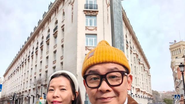 雷颂德移居英国做设计师，结婚18周年街边留影，妻子穿红袍好喜庆