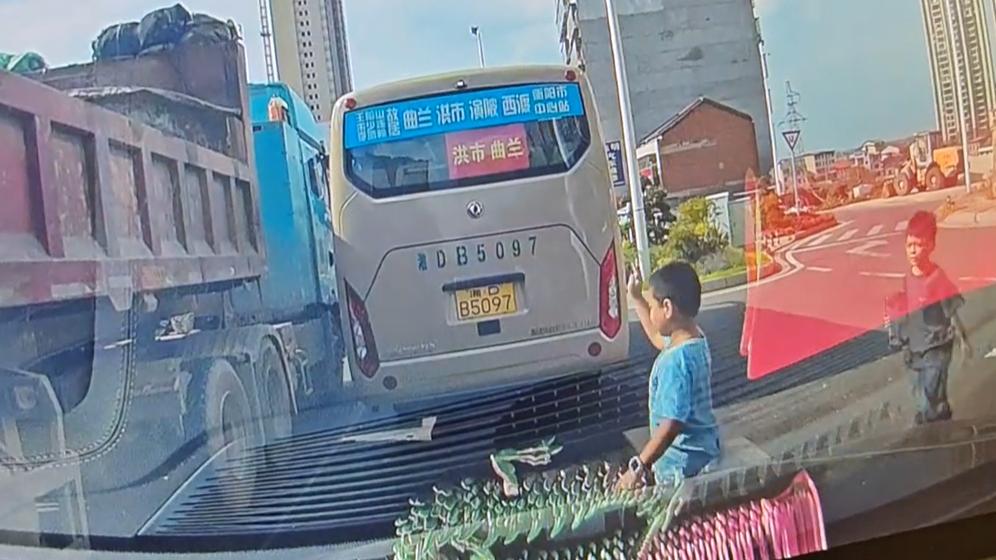 小孩哥趁货车等红灯时，钻进车下过马路，网友：差点害了货车司机