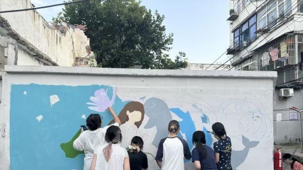 青年执彩绘江豚！武汉学院“长江生态画廊计划”点亮武昌老巷