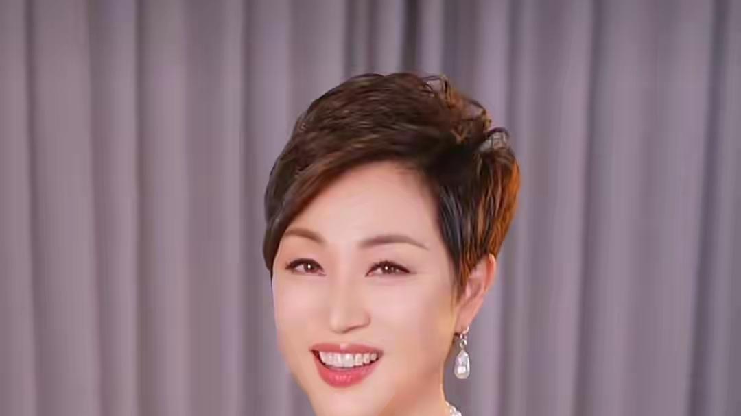 58岁陈法蓉，穿一字肩上衣和短裤跳手势舞