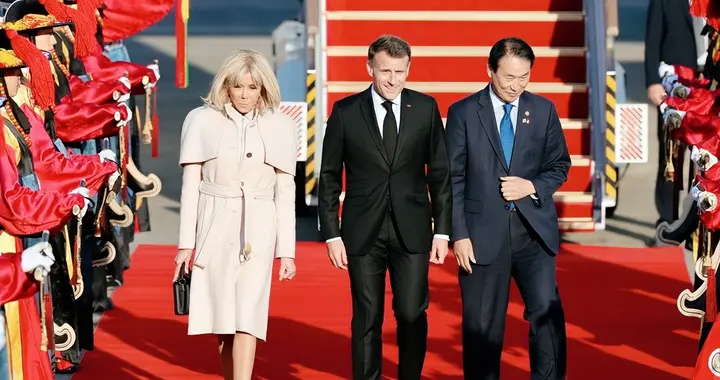 马克龙与夫人抵达韩国，夫人直接放大招，穿白风衣搭配披肩超有范