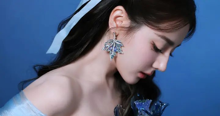 迪丽热巴身着轻盈纱裙，指尖萤光如星芒流转，尽显优雅气质