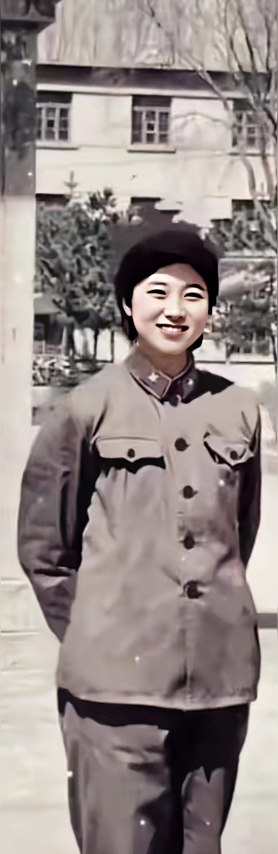 这是四十年前一位身着65式军装的女兵在部队医院门口的留影，女兵面容姣好...
