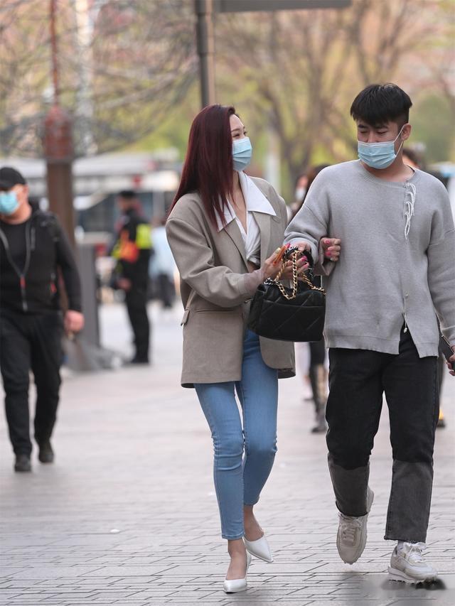 6厘米的白色尖头细跟鞋，搭配九分蓝色紧身牛仔裤，浅灰色的西服