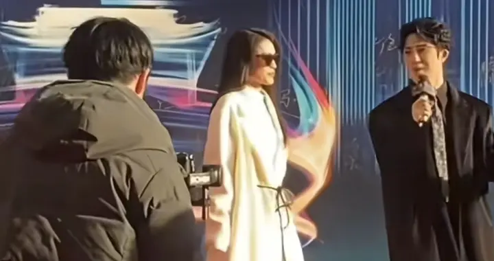 舒淇身着一袭白色长款大衣，戴着墨镜