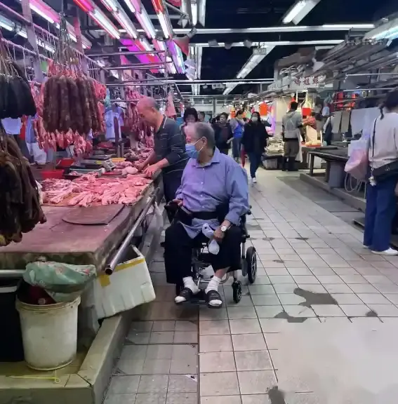 75岁洪金宝独自坐轮椅买菜，在档口仔细挑猪肉，穿凉鞋白发苍苍