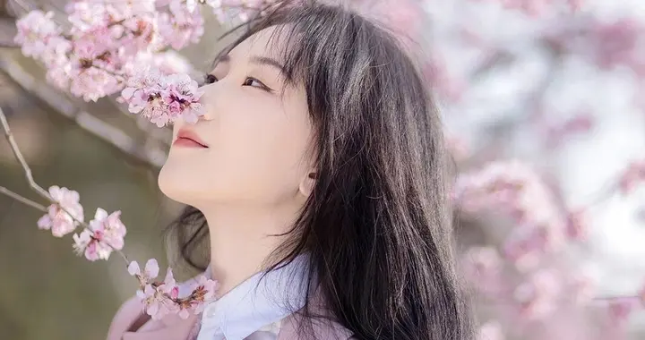 她微微仰着头，在看花