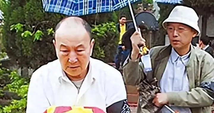 2014年，贺怡迁葬仪式上，儿子贺春生怀抱母亲的遗骨，神情肃穆