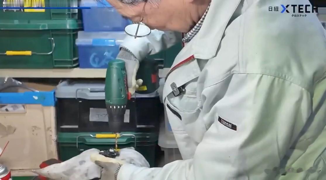 几名经验丰富的老技工使用工具小心翼翼地拆开了一台精美的机器人，他们如欣...