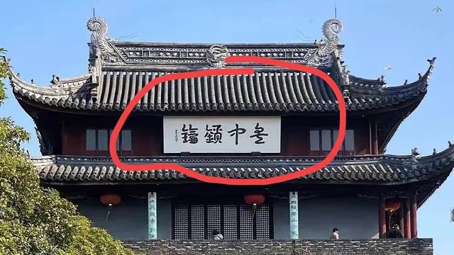 文化洞见：图中城楼牌匾上的四个字估计活有