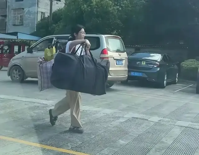 桂林高考女孩：一根圆木作扁担，挑担行李回家乡。