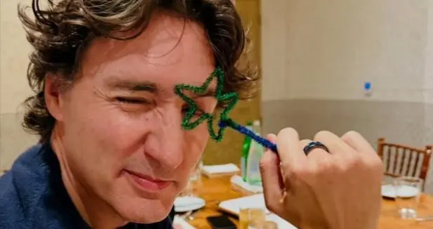 特鲁多与谷爱凌罕同框，一头卷发很有辨识度，双手背后尽显沉稳感