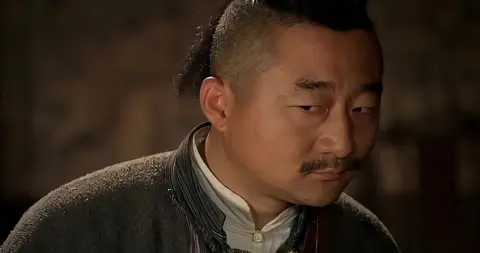 土匪头子躺在破庙地上，胸口往外冒血