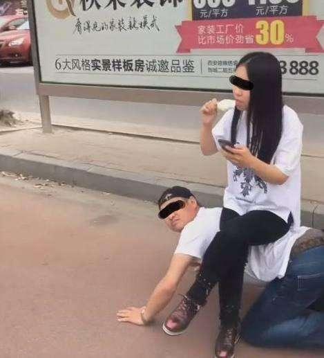 男子跪地给女友当凳子, 女友却坐着玩手机吃冰糕!