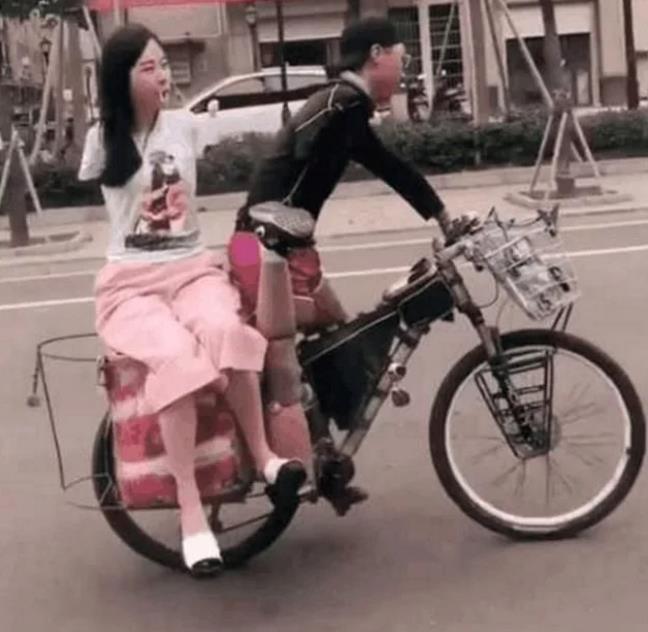 单腿男孩骑自行车载着无臂女孩, 车后竟然出现了这两个字, 路人羞红了脸