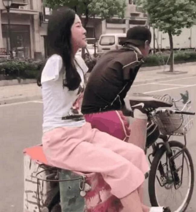 单腿男孩骑自行车载着无臂女孩, 车后竟然出现了这两个字, 路人羞红了脸
