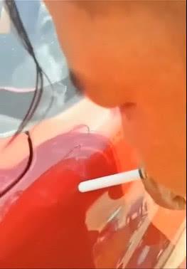 外面的温度太高, 男子竟然用汽车的外壳点着了烟