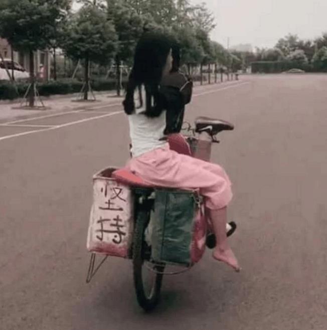 单腿男孩骑自行车载着无臂女孩, 车后竟然出现了这两个字, 路人羞红了脸
