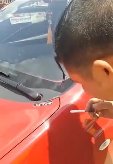 外面的温度太高, 男子竟然用汽车的外壳点着了烟