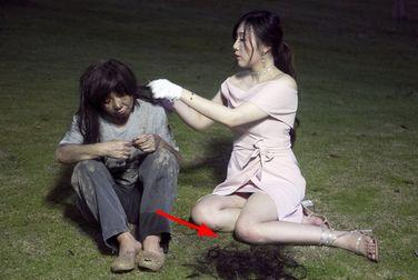 美女跪在地上给乞丐剪头发, 而乞丐却一脸的不屑
