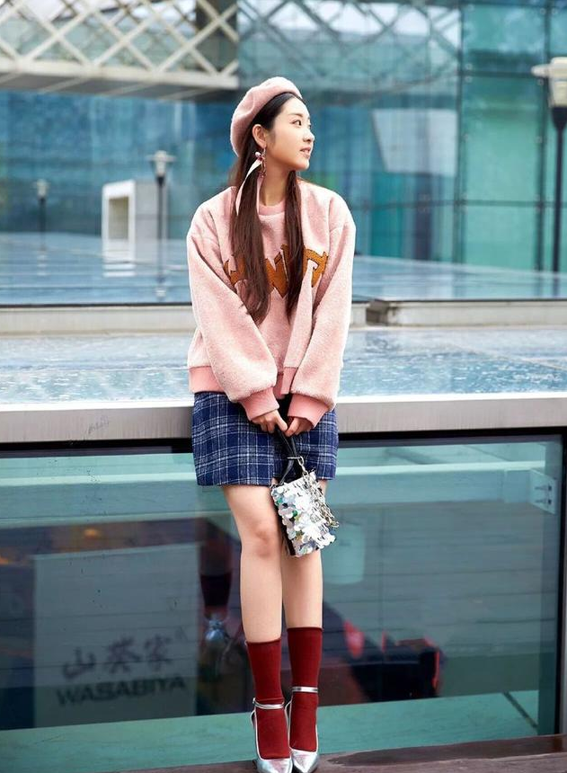 卫衣搭配一顶粉色的贝雷帽,下身搭配一条短裙,风格唯美又有少女气息