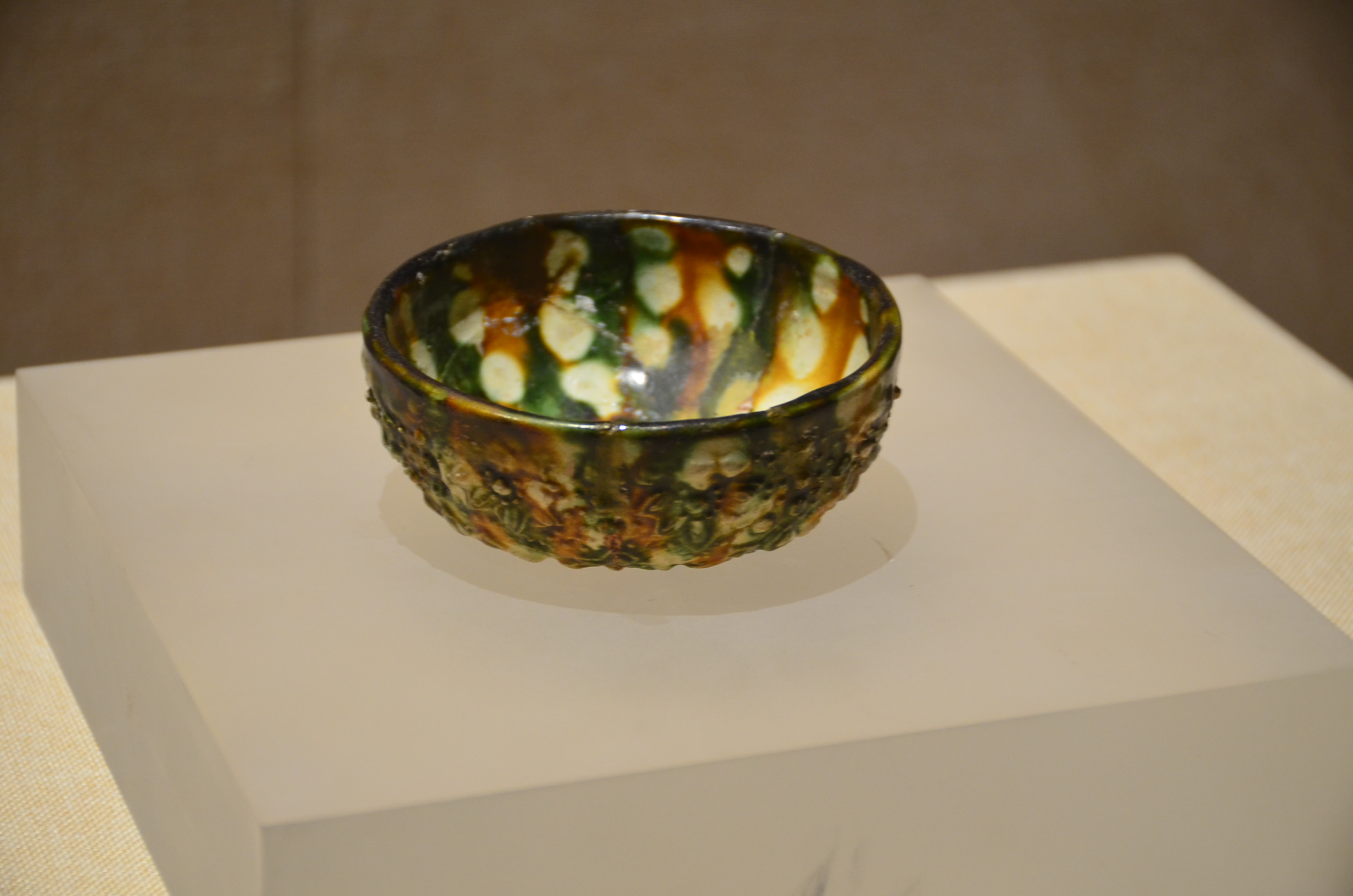 唐三彩雕花碗，碗底雕有凸纹，巧