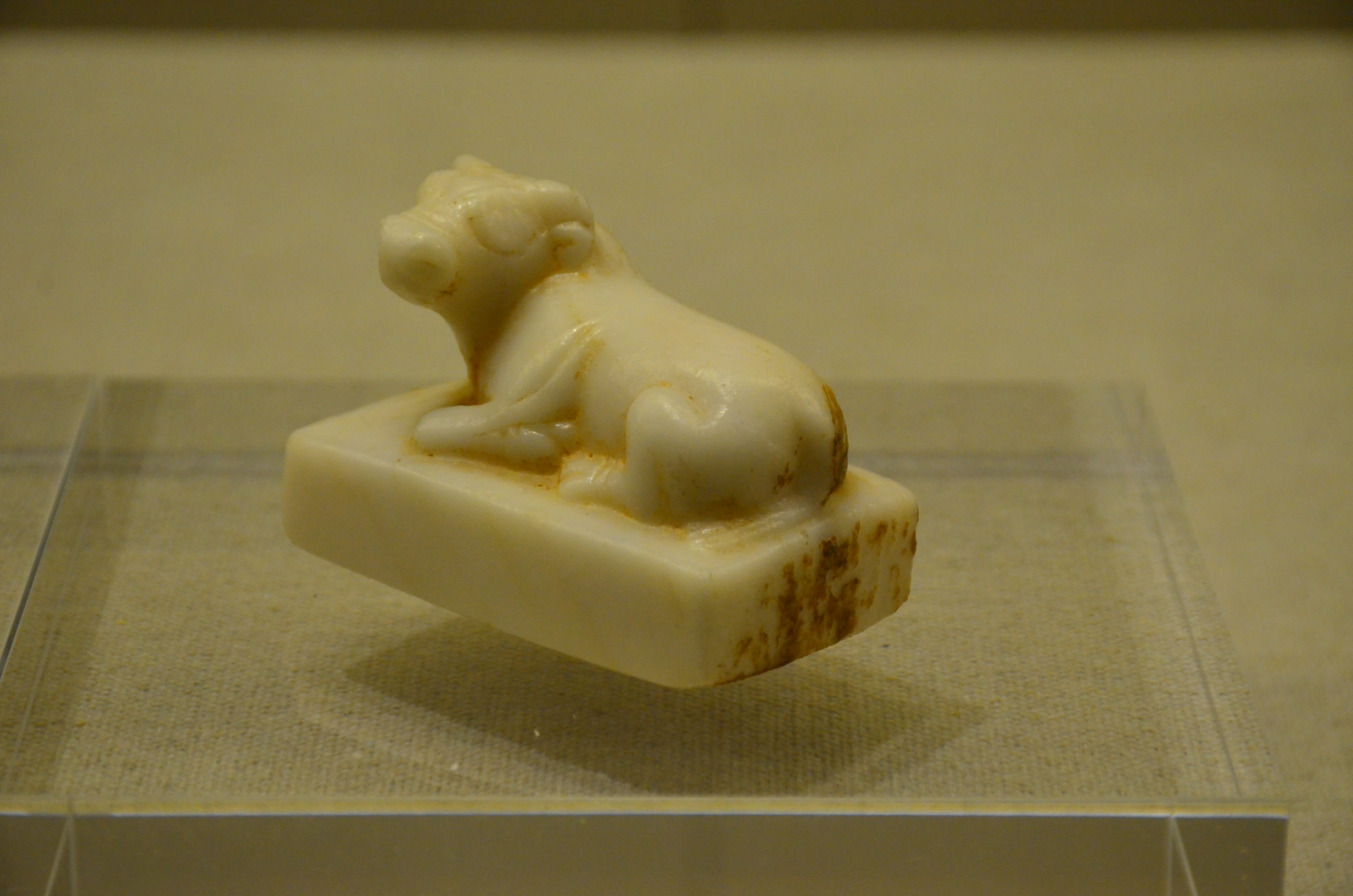 唐代乳色玻璃卧牛镇，是外形雕刻