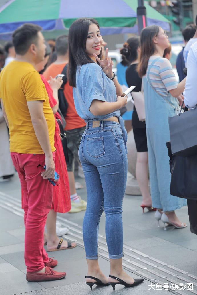 蓝色上衣搭配紧身牛仔裤,小姐姐身材微胖还穿这么紧的裤子,勒出赘肉太