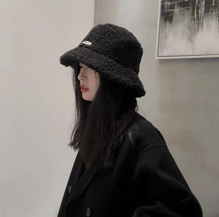 身穿一件卡其色的针织马甲,里边搭配一条红色碎花裙子,整个造型是真