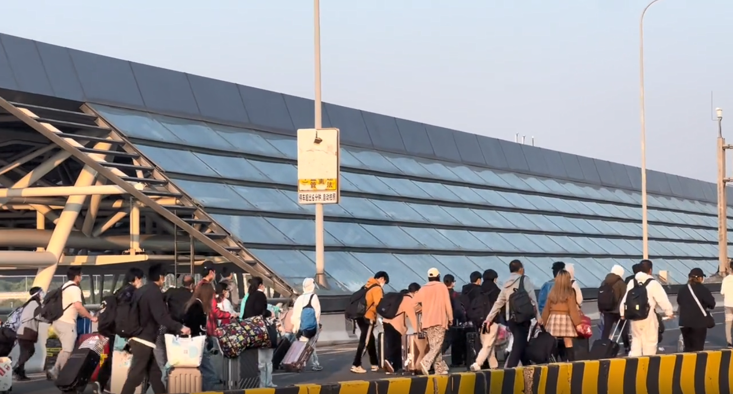 虹桥火车站前，离沪的人群……
