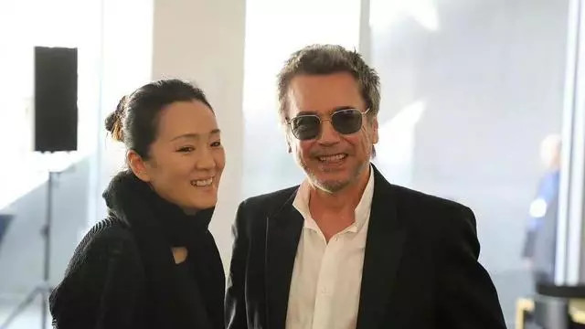 马克龙双手紧握巩俐，笑着说：“巩老师，我看你戏长大的！”