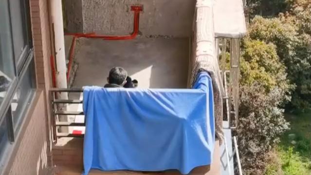 上海一装修工被封毛坯20天，独坐阳台晒太阳，男子隔空喊话送温暖