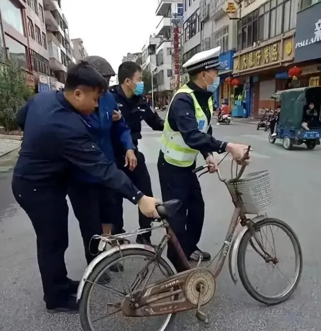 这张照片拍摄于2023年，上海退休法学教授李自忠骑自行车接孙女上放学时，被交警以