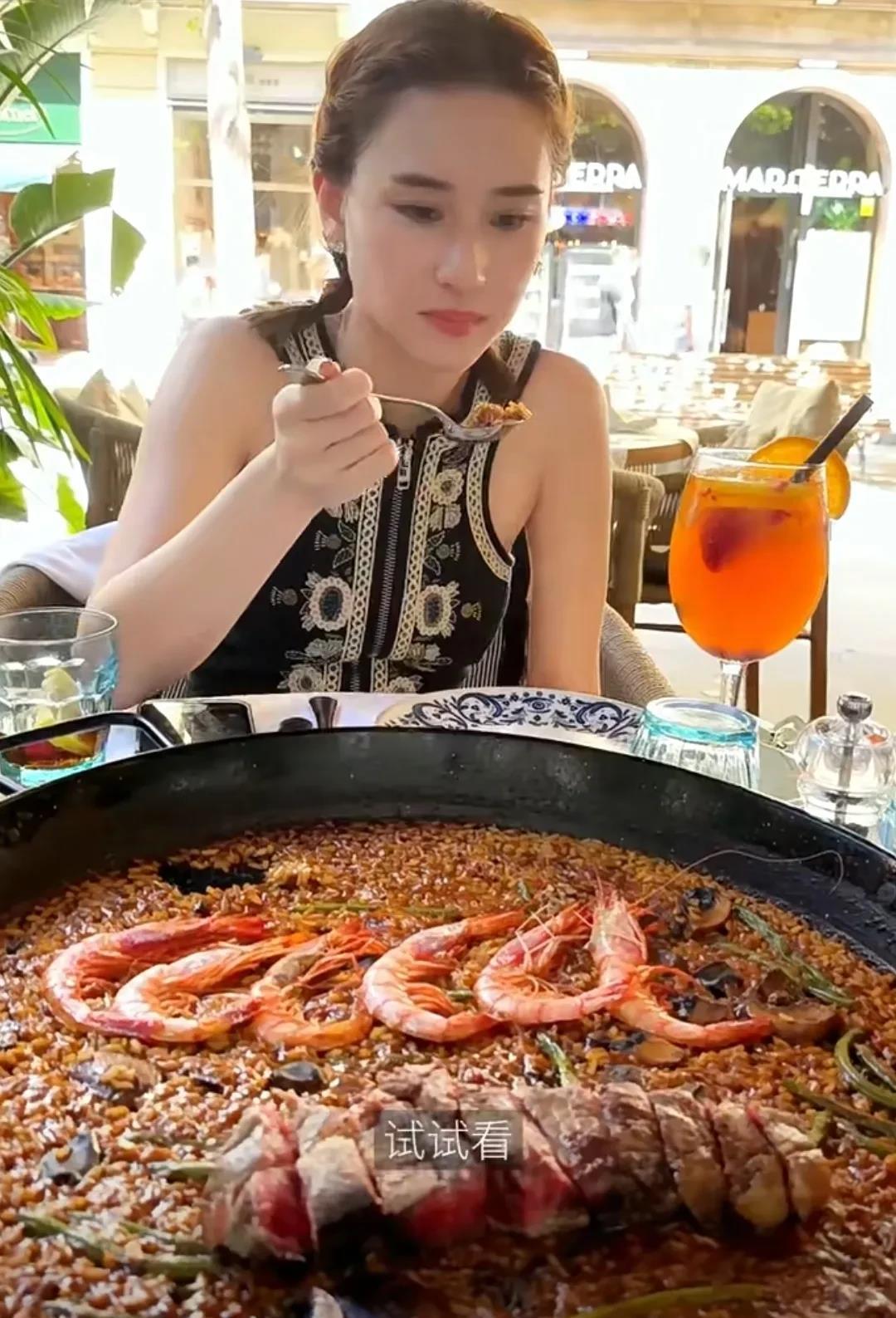 何超莲在巴塞罗那，打卡街头海鲜大餐，她很喜欢大虾和生蚝，点的菜上来以后还不忘先拍