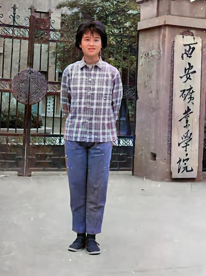 这张照片拍摄于1994年，一位年轻女孩站在西安矿业学院门口留下了这张照片。她穿着