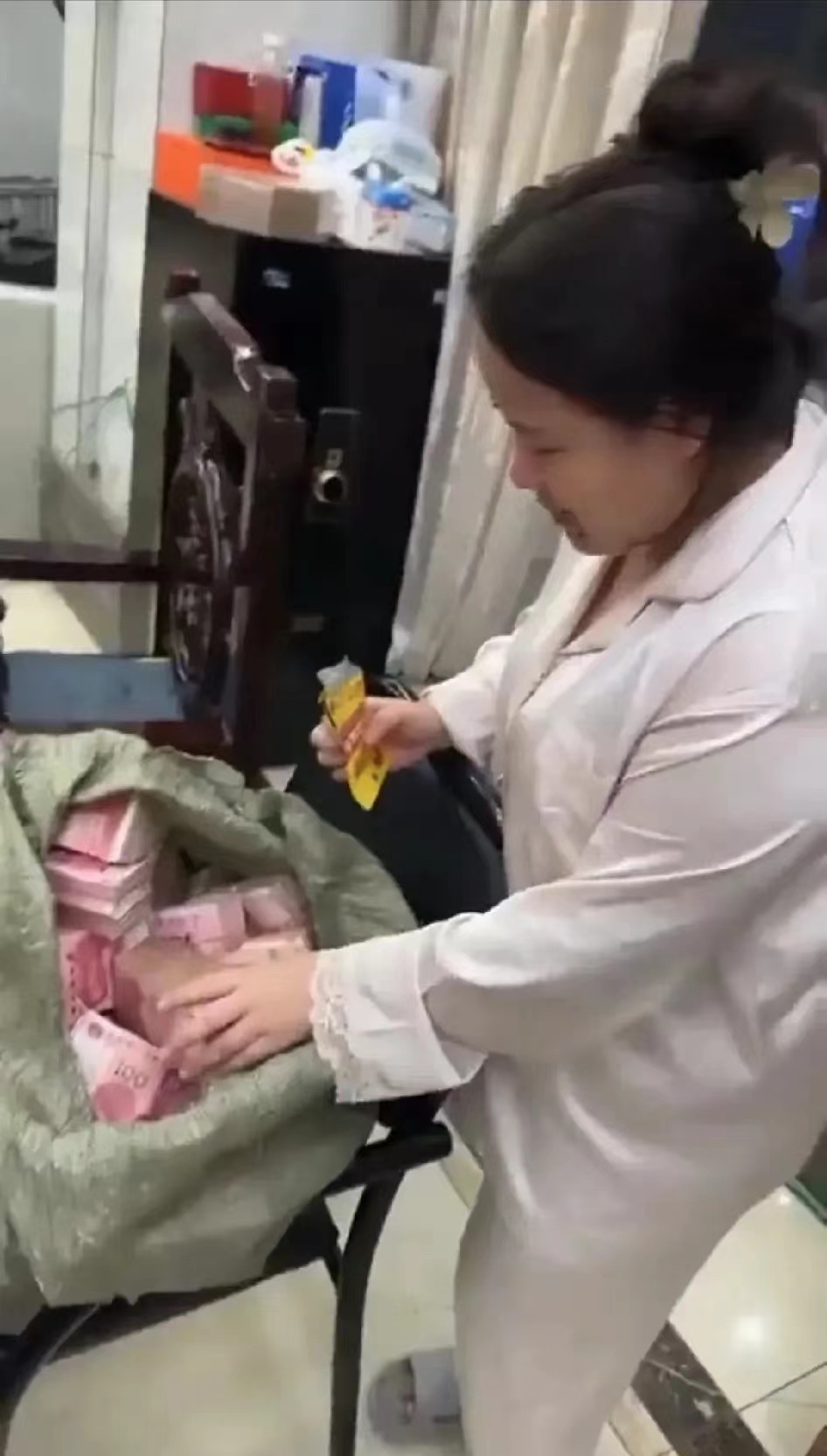 网传这是明珍珍“点钱”的画面。她身穿米白色睡衣水库，这显然是在自己的家里面。随手