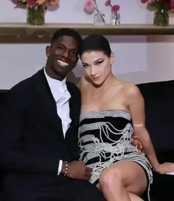 这是比尔盖茨的女儿与其黑人男友的合照。这位黑人小伙开心地笑着，而盖茨的女儿则靠在