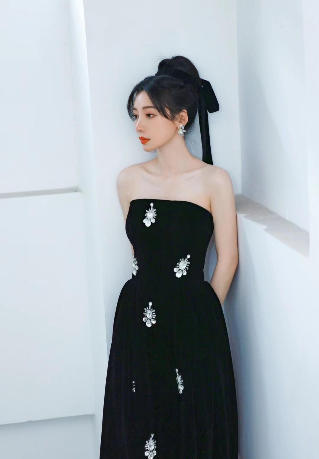 柳岩，一身黑色稳重抹胸长裙，头系黑色丝带，妆容精致，一改往日风格，凸显了几分清新